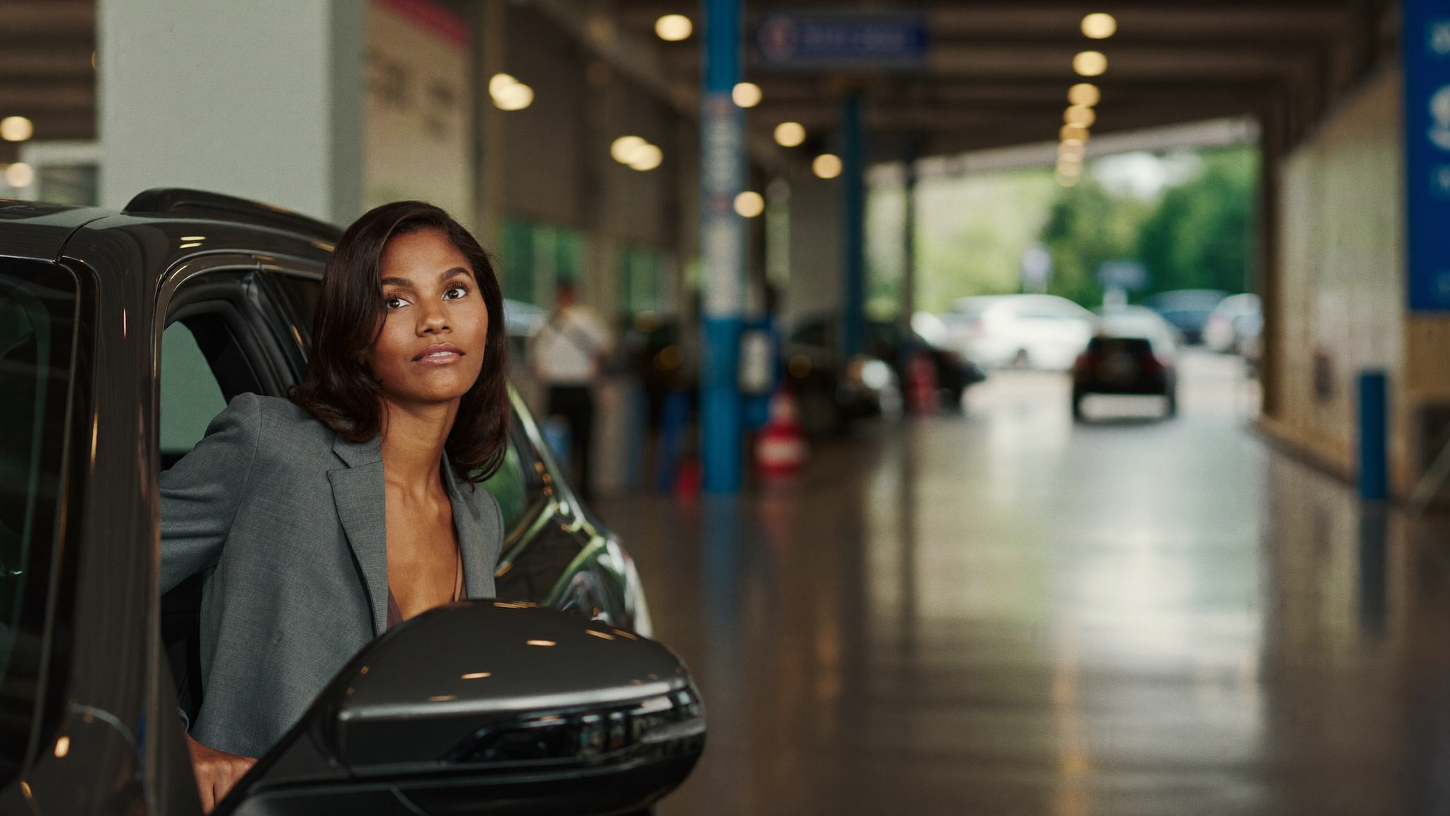 Woman beside SUV at dealership service drive