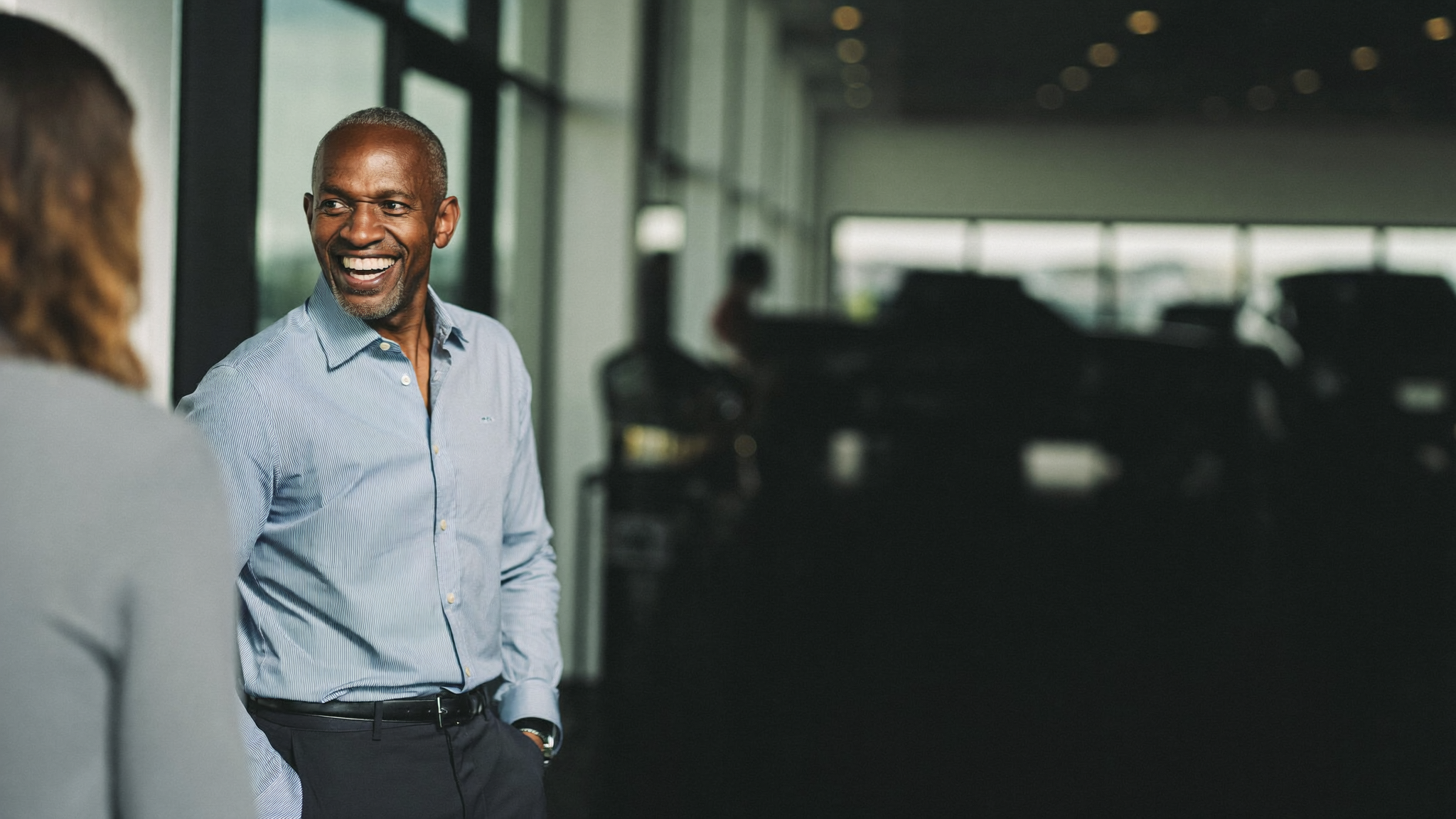 Returning customer warmly greeted in dealership showroom